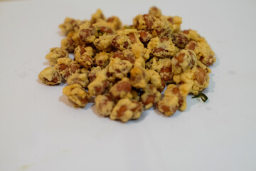 Fried peanuts or kacang disco are a typical Balinese on a white background, Indonesian snack. It tastes so delicious. Made from peanuts and spices with a savory and crunchy taste.