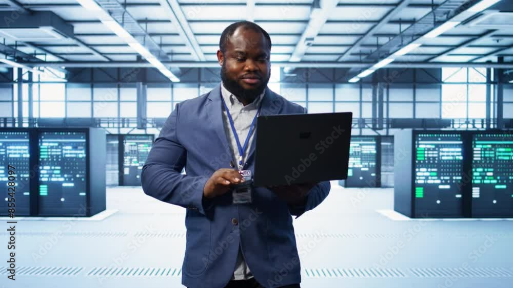 Poster it engineer working on laptop in modern data center, overseeing server operations, system maintenanc