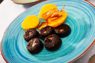 Delicious blood sausages with garnish of potatoes and grilled onion