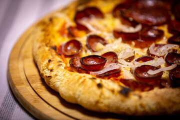 Calabrian sausage pizza served on a round board and set table