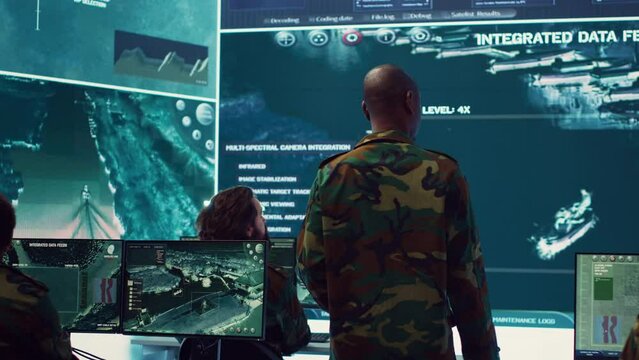 General headquarters under ruling of army IT professional that reviews insight about a new national safety mission. Command sergeant major briefing his marine corps troops with big data. Camera A.