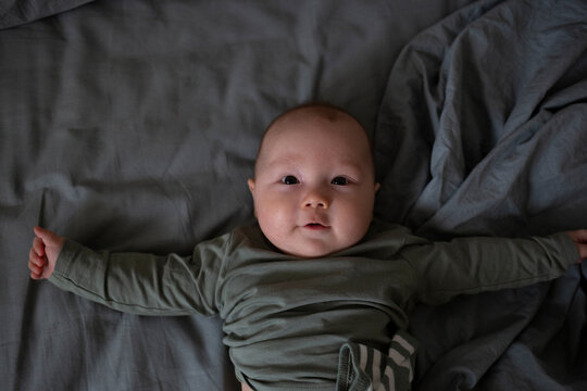 An adorable baby smiling happily while lying down, capturing a moment of pure innocence