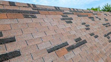 Roof with missing shingles from storm damage and old age