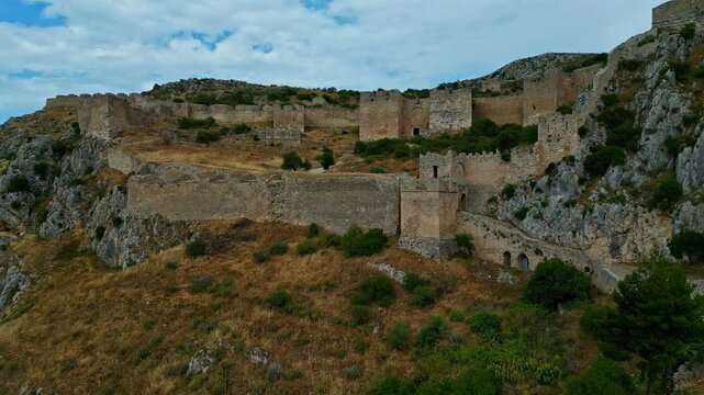 Aerial rising shot of the Acrocorinth castle saulestari ruins in cloudy Greece