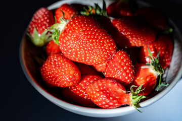 Plate with french organic red ripe sweet strawberries Fraises de Plougastel, harvested in France