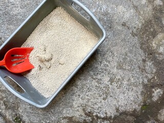 Clump the cat feces in the litter box with an orange scoop