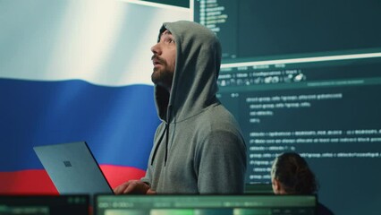Russian cyber forces operative working with computer systems in a governmental hacking room. Inflicting cyberterrorism, fake news and dangerous brainwashing, digital mercenary activities. Camera A.