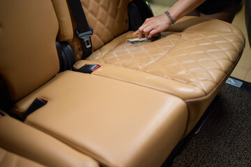 Clean leather car seats with brush and plastic cover for luxury interior maintenance and hygiene