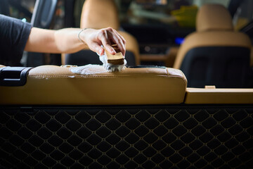 Clean leather car seats with brush and plastic cover for luxury interior maintenance and hygiene