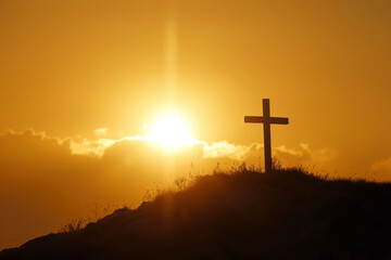 Silhouette of a Christianity Cross on top of a hill with golden sun light at background. Generative AI