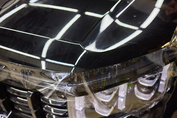 Workshop process of applying protective film to safeguard car headlights from scratches and damage