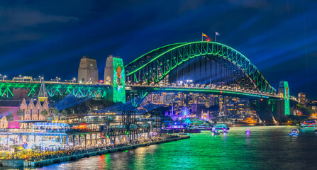 Colourful Light show at night on Sydney Harbour NSW Australia. The bridge illuminated with lasers and neon coloured lights  Vivid Sydney Laser and Light Drone show