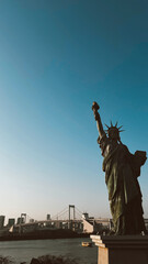 Fototapeta premium Odaiba, Tokyo. March 13, 2024: Statue of Liberty in Tokyo with beautiful sunset. 