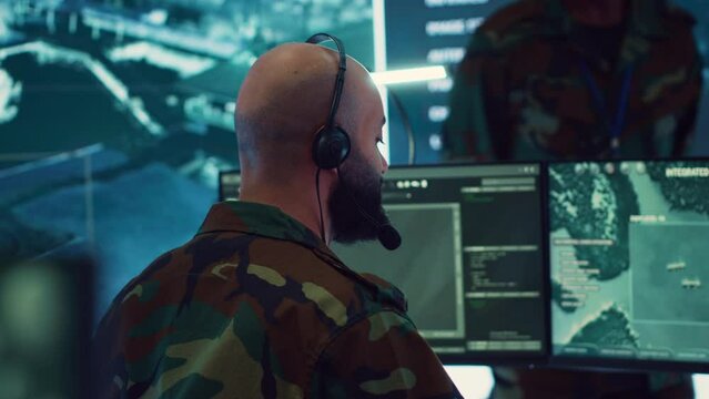 Male IT specialist operating on reconnaissance system to transmit real time data for new field mission, working in military command center. Telecommunications operator provides air support. Camera A.