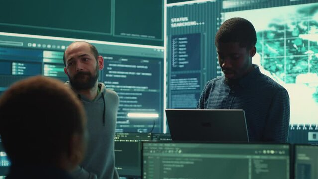 Governmental hackers performing a cyber attack simulation after studying the national database servers. Experts working on IT security, data breach prevention against ransomware. Camera A.