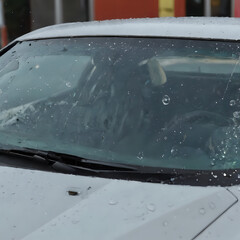 a driving in a car with rain on the windshield