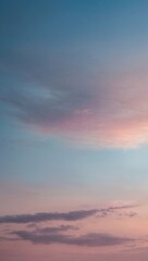 Fototapeta premium A beautiful gradient sky with soft pink and blue hues, featuring wispy clouds at sunset, background