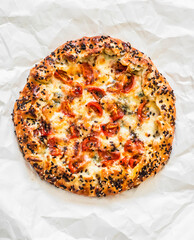 Mediterranean galette with cherry tomatoes, spinach, ham and mozzarella on a light background, top view