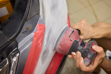 Person using a machine to polish automotive lighting on a car headlight