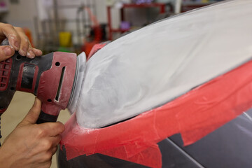 Person using a machine to polish automotive lighting on a car headlight