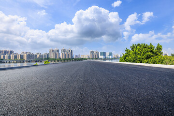 Fototapeta premium Straight highway road and city skyline on a sunny day