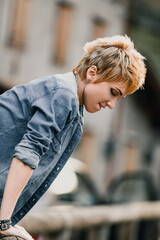 Young woman leaning forward wearing denim shirt and bracelet