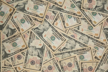 $10.00 bills background. Ten dollar US bank notes spread out.