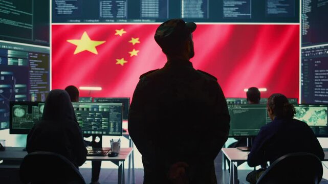 Chinese military personnel in a high tech government hacking room work on stealing state secrets from rival countries in hybrid war. Chinese army exploit advanced technology, inflict fear. Camera B.