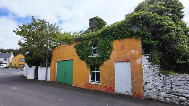 Ireland epic Locations Eyeries West Cork , brightly coloured ruined house overgrown with ivy, main street in the village