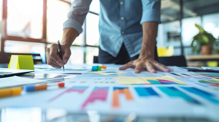 Obraz premium Business professional analyzing financial data with charts and graphs on a desk, focusing on growth and strategic planning in an office setting.