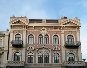 Obraz premium Facade of a pale pink building with stucco, columns and many windows, Tbilisi, Georgia