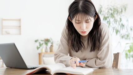 自宅で資格の勉強をする女性