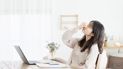 パソコン作業に目の疲れを感じる女性
