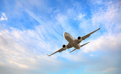 White passenger airplane flying in the sky amazing clouds in the background - Travel by air...