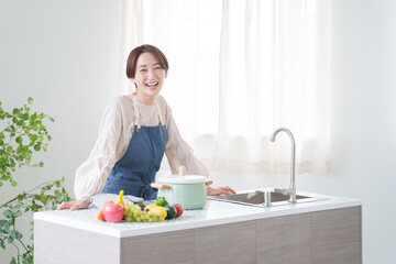 キッチンで料理をする女性（家事・主婦・自炊）