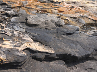 Volcanic rock ground with hot thermal spring and orange Sulphur sediments, Ibusuki coast