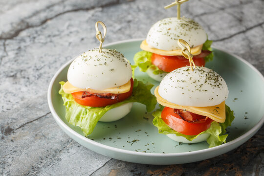Easter Egg Appetizer Skewers with cheese, bacon, tomato and lettuce close-up in a plate on the table. Horizontal