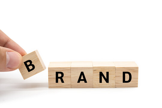 Hand place wooden blocks with BRAND text isolated on white background. Build your Brand. Brand building, success, business. Copy space and clipping path.