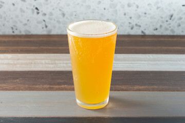 A view of a light colored beer in a glass.