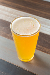 A view of a light colored beer in a glass.
