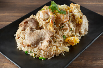 A view of a plate of fried rice, featuring pork and shrimp.