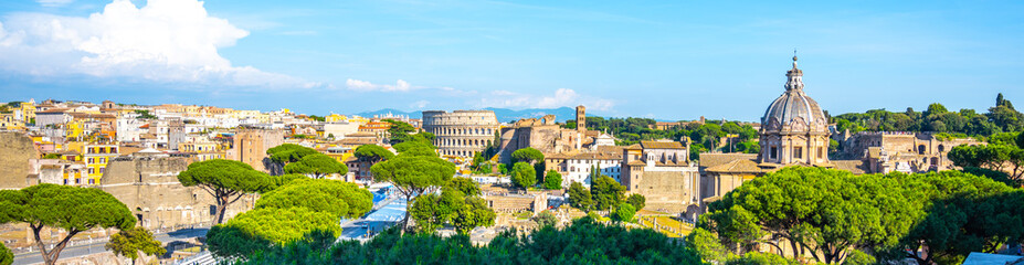 A panoramic view of the Roman Forum and Colosseum in Rome, Italy. The ancient ruins are surrounded by lush greenery, creating a striking contrast between history and nature.