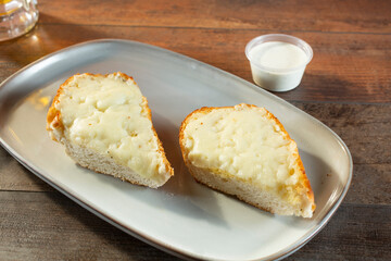 A view of a plate of cheesy garlic bread.