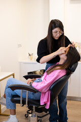 Beautician making eyelash lamination and dyeing procedures. Young latin woman in a professional...
