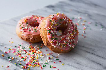 A view of some rainbow sprinkle donuts.