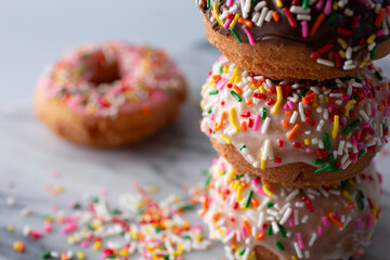 A closeup view of a stack of rainbow sprinkle donuts.