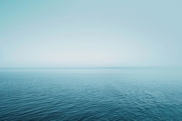 Obraz premium A vast expanse of water reflecting the clear blue sky above, A soft gradient of light blue tones blending seamlessly