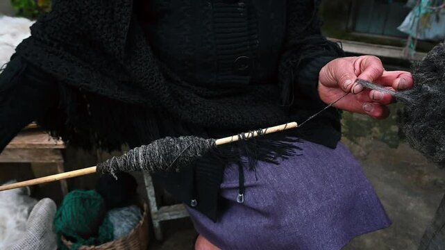 woman's hands spinning wool in a traditional way