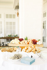Elegant food display with cheeses, bread, crackers, and fruits