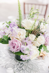 Florals with lavender roses white flowers and ferns on decorated table